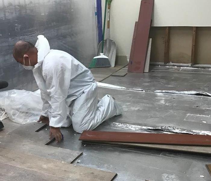 Technician removing floorboards